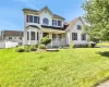 Colonial-style house with a front yard and a porch Colonial-style house with a front yard and a porch