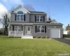 Traditional-style house featuring an attached garage, covered porch, driveway, and a front lawn Traditional-style house featuring an attached garage, covered porch, driveway, and a front lawn
