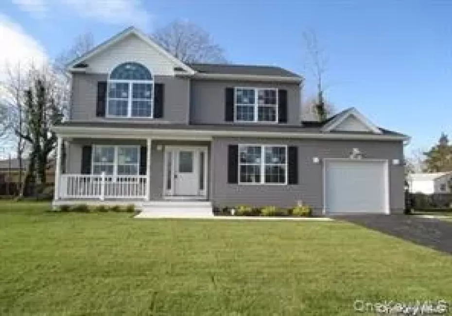 Traditional-style house featuring an attached garage, covered porch, driveway, and a front lawn Traditional-style house featuring an attached garage, covered porch, driveway, and a front lawn