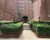 Brick exterior multi-story building featuring a central entrance with a green awning and integrated lighting Brick exterior multi-story building featuring a central entrance with a green awning and integrated lighting