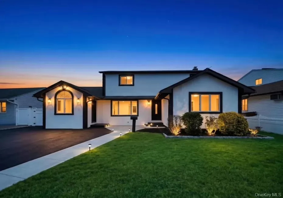 Modern-style exterior featuring a white facade with dark trim, an arched window, and multiple outdoor sconces Modern-style exterior featuring a white facade with dark trim, an arched window, and multiple outdoor sconces