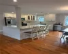 Kitchen featuring white shaker cabinetry, stainless steel appliances, light-toned countertops, and wood-finish flooring Kitchen featuring white shaker cabinetry, stainless steel appliances, light-toned countertops, and wood-finish flooring