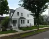 Gambrel roof architecture with white siding, a covered entry porch, and a paved walkway Gambrel roof architecture with white siding, a covered entry porch, and a paved walkway