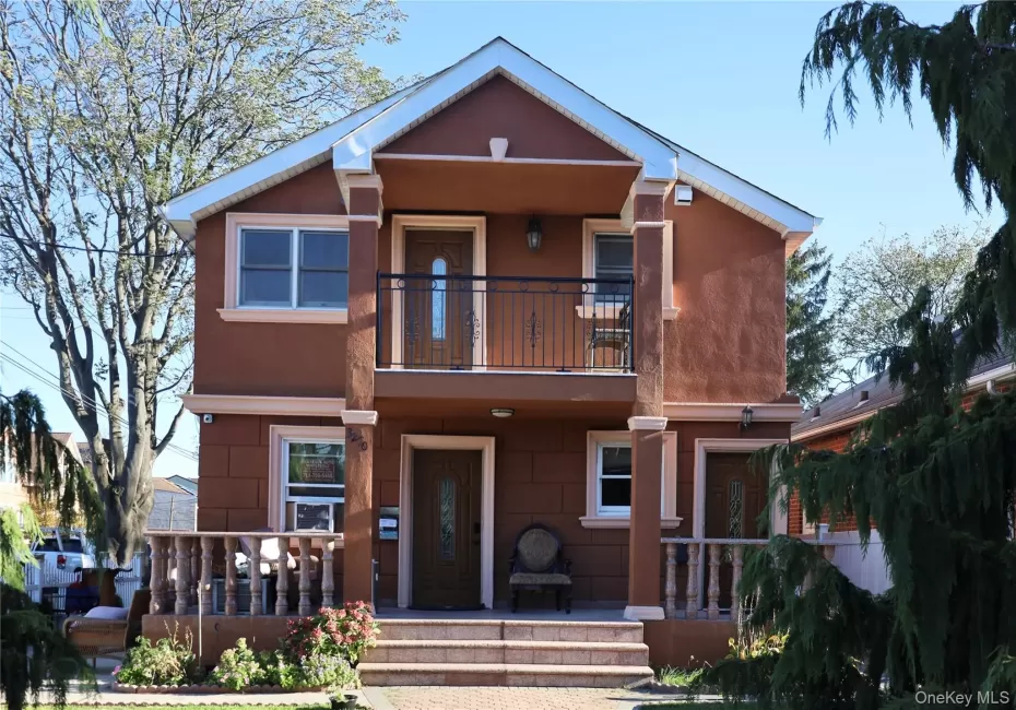 View of front facade with a porch, stucco siding, and a balcony View of front facade with a porch, stucco siding, and a balcony
