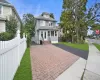Two-story residence with a covered porch, dormer windows, and a paved driveway Two-story residence with a covered porch, dormer windows, and a paved driveway