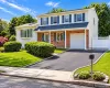 Two-story exterior with brick and siding facade, covered entry, attached garage, paved driveway, and manicured landscaping Two-story exterior with brick and siding facade, covered entry, attached garage, paved driveway, and manicured landscaping