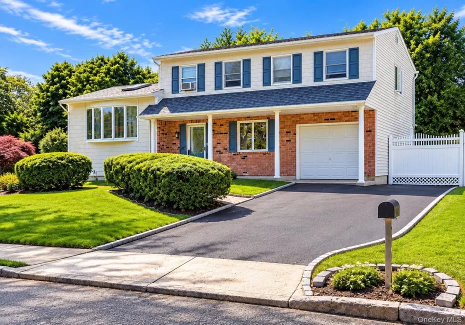 Two-story exterior with brick and siding facade, covered entry, attached garage, paved driveway, and manicured landscaping Two-story exterior with brick and siding facade, covered entry, attached garage, paved driveway, and manicured landscaping