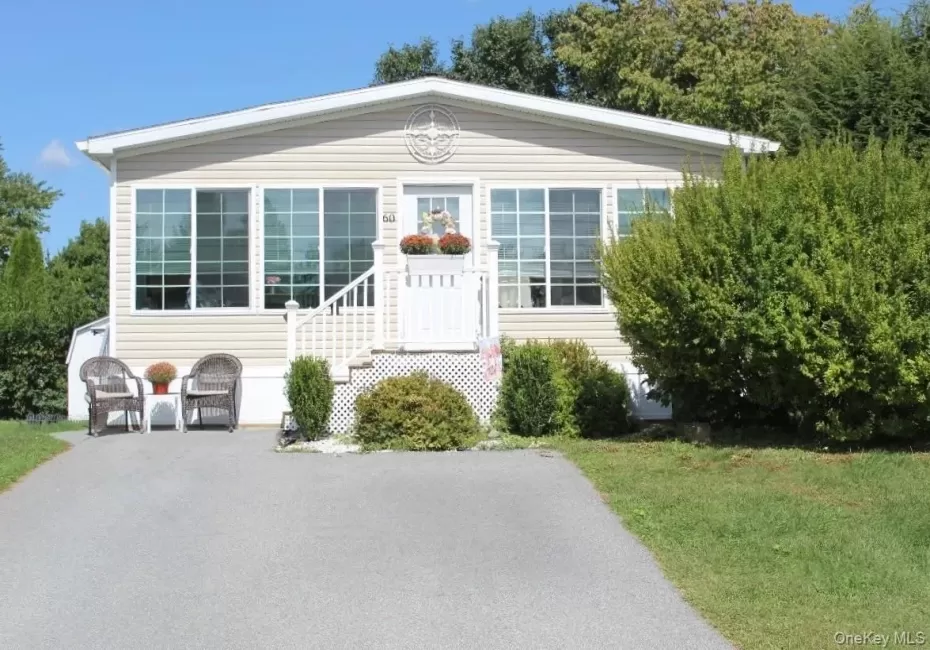 Single-story residence featuring light-toned horizontal siding and a prominent front entrance.with white railings Single-story residence featuring light-toned horizontal siding and a prominent front entrance.with white railings