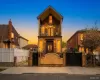 Brick facade residence featuring a prominent front entrance with dual doors, a second-story balcony with iron railings, and a gabled roofline. A.I Enchanced Brick facade residence featuring a prominent front entrance with dual doors, a second-story balcony with iron railings, and a gabled roofline. A.I Enchanced