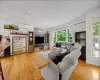 Bright living area featuring wood-finish flooring, recessed lighting, and white crown molding Bright living area featuring wood-finish flooring, recessed lighting, and white crown molding