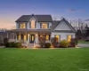 Two-story residence featuring a full-width front porch, central arched window, and prominent gable rooflines Two-story residence featuring a full-width front porch, central arched window, and prominent gable rooflines