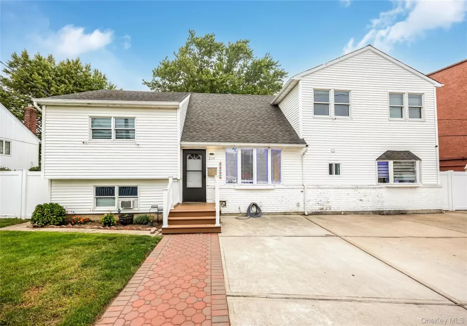 Tri-level home featuring a shingled roof and brick siding Tri-level home featuring a shingled roof and brick siding