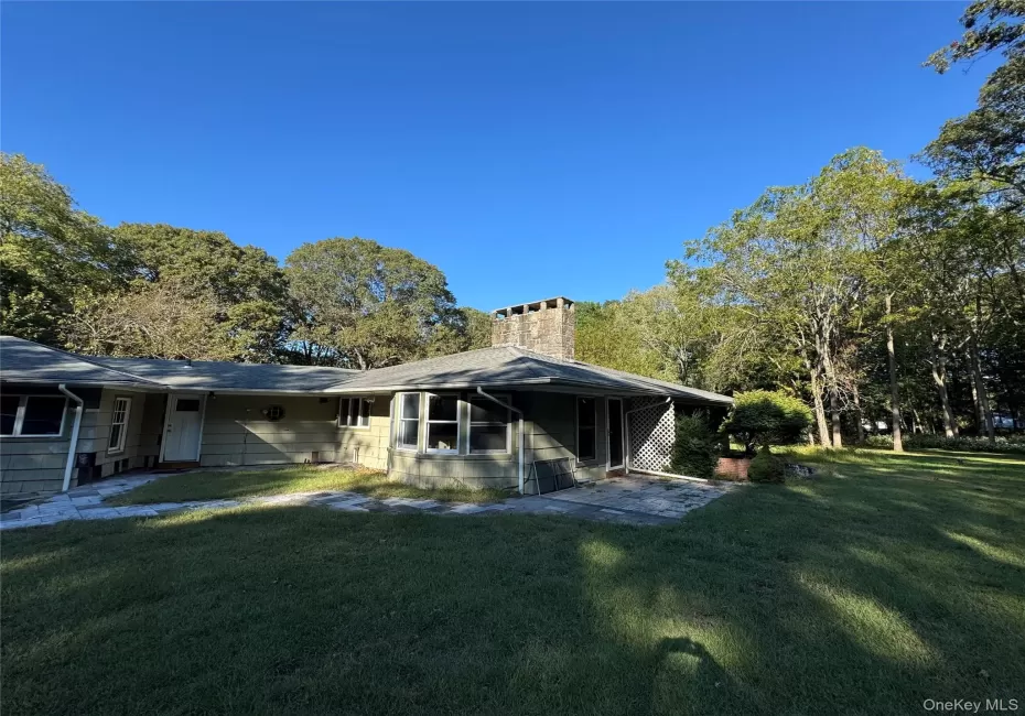 View of property exterior featuring a lawn and a chimney View of property exterior featuring a lawn and a chimney