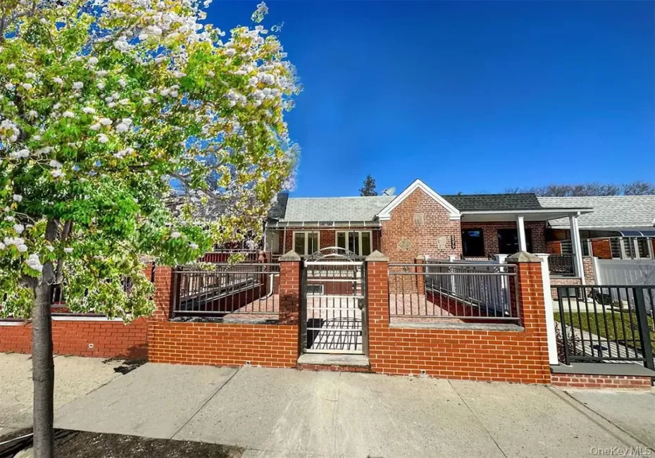 Brick facade property featuring a gabled entryway, a covered porch, and a private fenced front yard with a gate Brick facade property featuring a gabled entryway, a covered porch, and a private fenced front yard with a gate