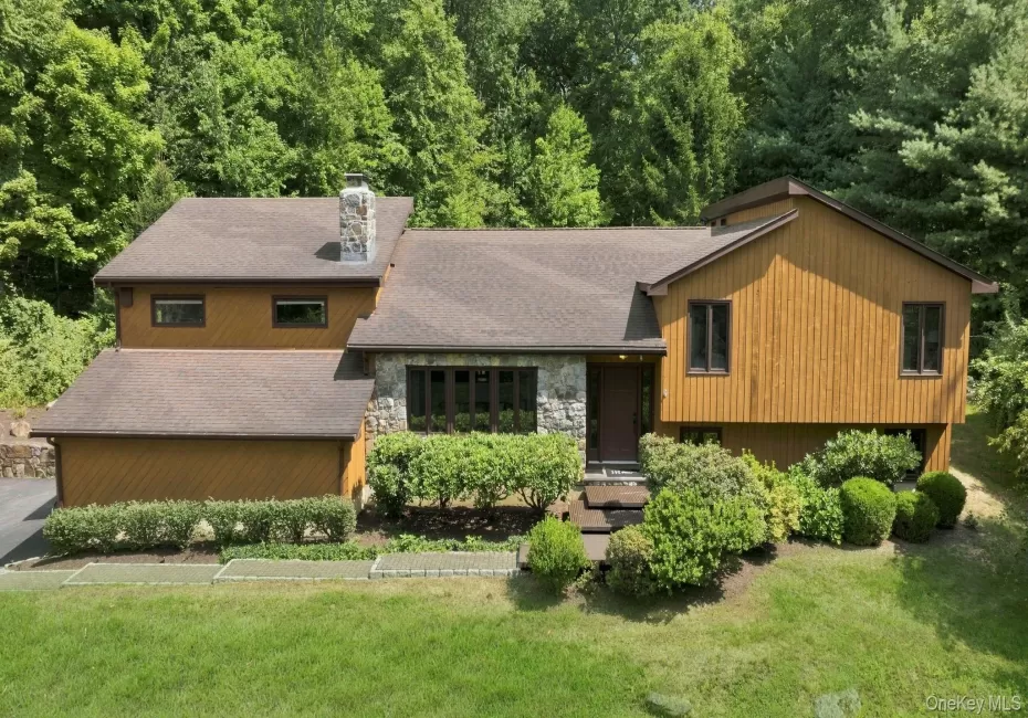 Wood-finish siding with stone accents and a stone chimney Wood-finish siding with stone accents and a stone chimney