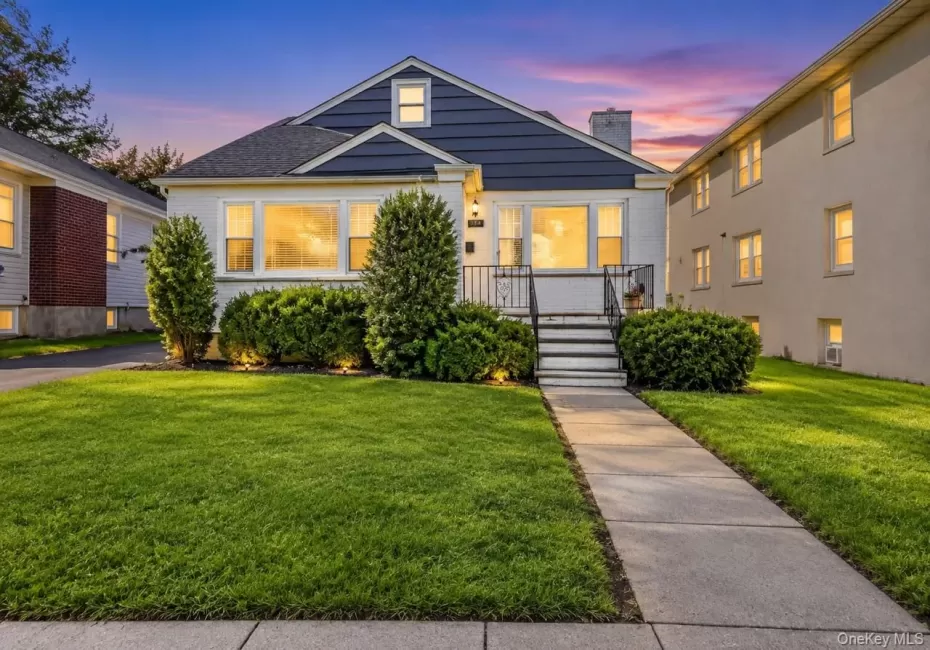 Front exterior featuring a gabled roof, white siding, and dark blue shingle accents Front exterior featuring a gabled roof, white siding, and dark blue shingle accents