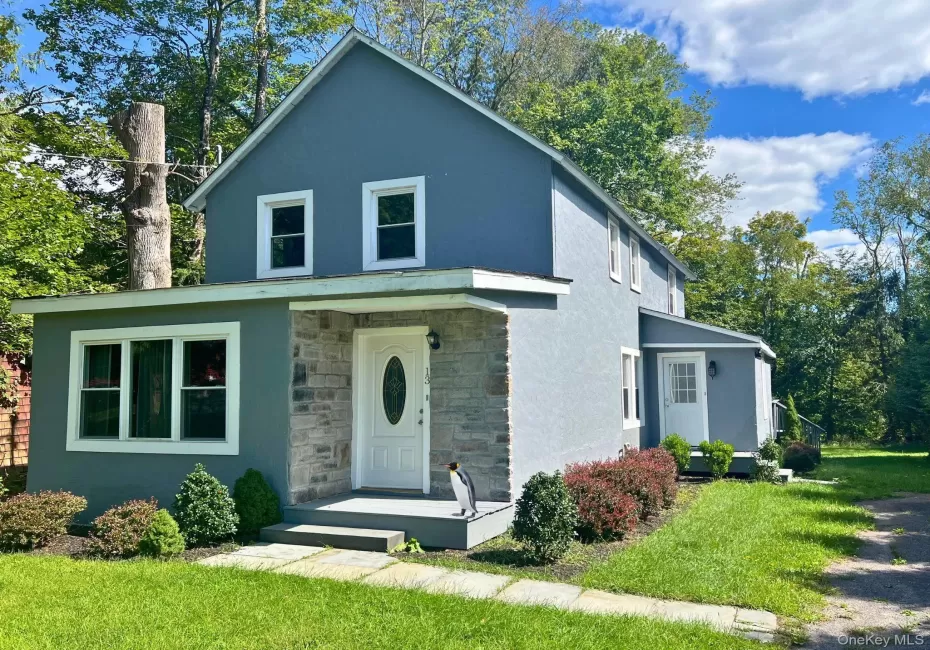 Stone veneer facade accenting the main entrance, multiple window styles, and a paved walkway Stone veneer facade accenting the main entrance, multiple window styles, and a paved walkway