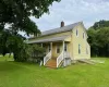 Two-story residence with yellow siding and white trim Two-story residence with yellow siding and white trim