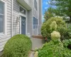 Private end unit entry framed by shrubs and a perennial garden Private end unit entry framed by shrubs and a perennial garden