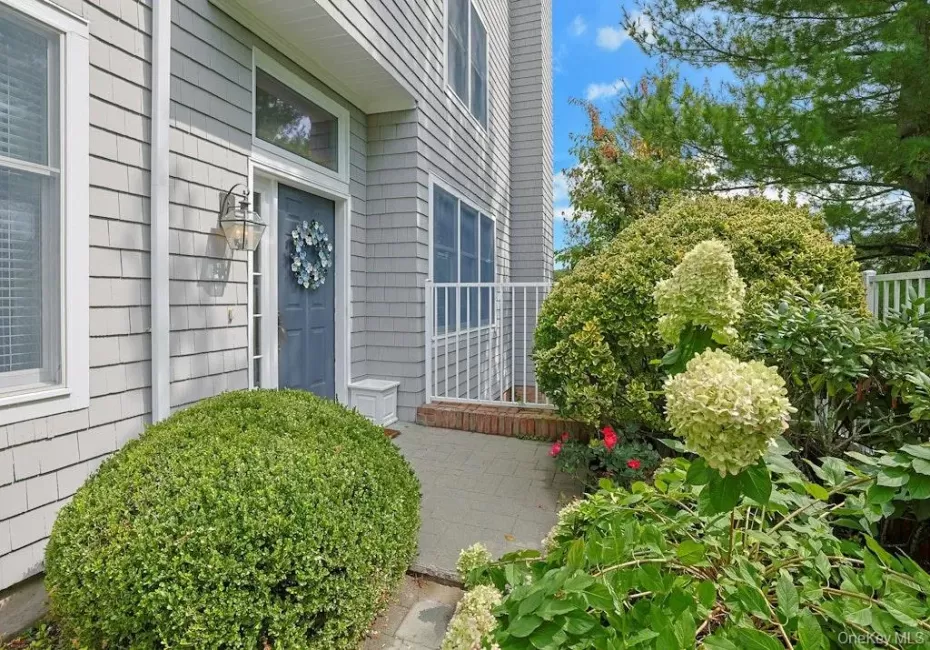 Private end unit entry framed by shrubs and a perennial garden Private end unit entry framed by shrubs and a perennial garden