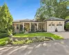 View of front of property with a porch, stucco siding, decorative driveway, a garage, and a front yard View of front of property with a porch, stucco siding, decorative driveway, a garage, and a front yard