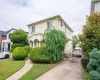 View of front of house with stucco siding, a wall mounted AC, and a front lawn View of front of house with stucco siding, a wall mounted AC, and a front lawn