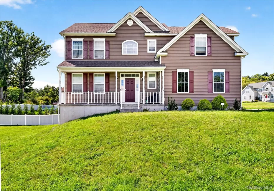 Brown siding exterior with white trim, covered front porch, front entry door with sidelights, and a sloped front lawn Brown siding exterior with white trim, covered front porch, front entry door with sidelights, and a sloped front lawn