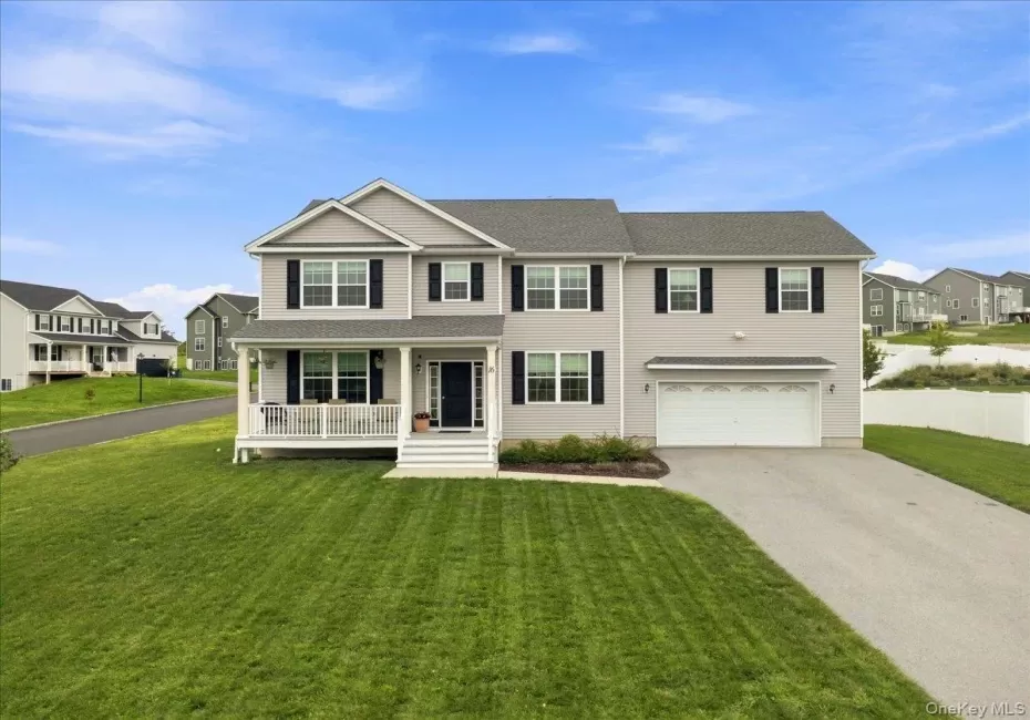 Two-story residence featuring light gray siding with contrasting black shutters, a covered front porch, an attached two-car garage, and a paved driveway Two-story residence featuring light gray siding with contrasting black shutters, a covered front porch, an attached two-car garage, and a paved driveway