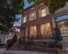 Brick facade with decorative shutters, classic entry columns, and a wrought iron fence Brick facade with decorative shutters, classic entry columns, and a wrought iron fence