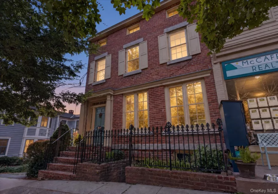 Brick facade with decorative shutters, classic entry columns, and a wrought iron fence Brick facade with decorative shutters, classic entry columns, and a wrought iron fence