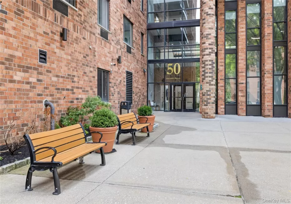 Brick exterior with a prominent glass entry, multiple large windows, and a concrete paver walkway Brick exterior with a prominent glass entry, multiple large windows, and a concrete paver walkway