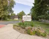 Lake Road Condominium entrance sign with a landscaped flower bed, mature trees, and a two-story building in the background Lake Road Condominium entrance sign with a landscaped flower bed, mature trees, and a two-story building in the background