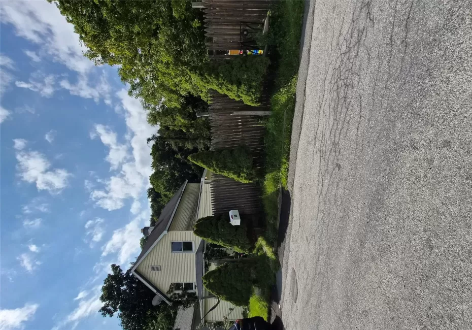 Front of home lined with wooden fence and evergreens. Front of home lined with wooden fence and evergreens.