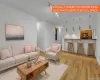 Open concept living area featuring wood-finish flooring and a breakfast bar Open concept living area featuring wood-finish flooring and a breakfast bar