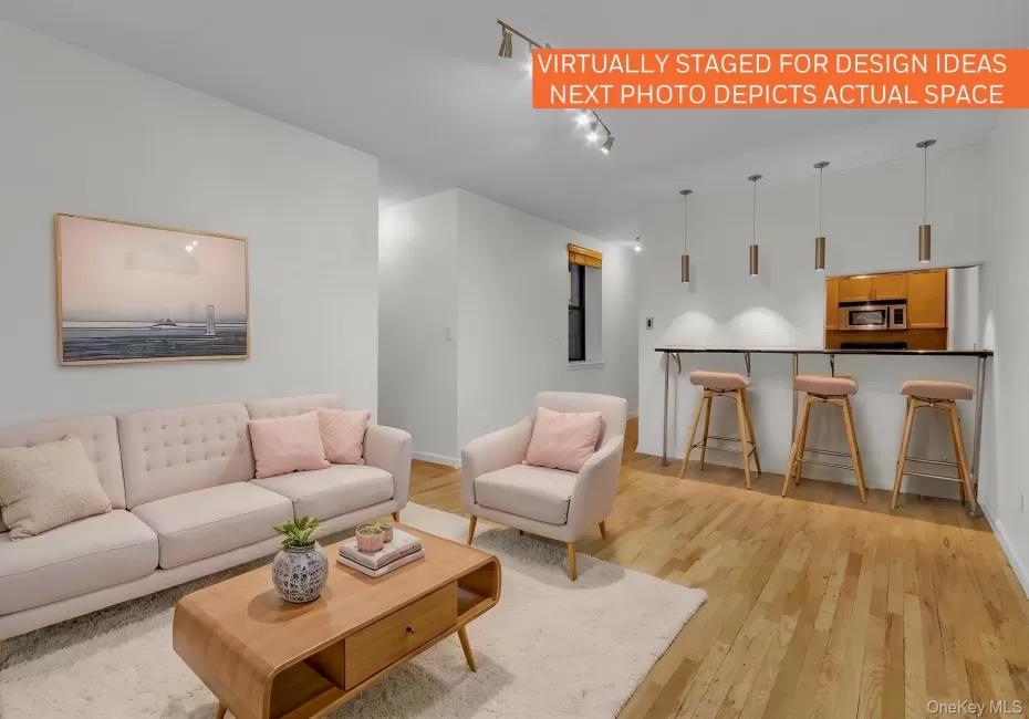 Open concept living area featuring wood-finish flooring and a breakfast bar Open concept living area featuring wood-finish flooring and a breakfast bar