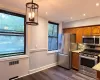 Wood-finish flooring, recessed lighting, and a contemporary ceiling fixture Wood-finish flooring, recessed lighting, and a contemporary ceiling fixture