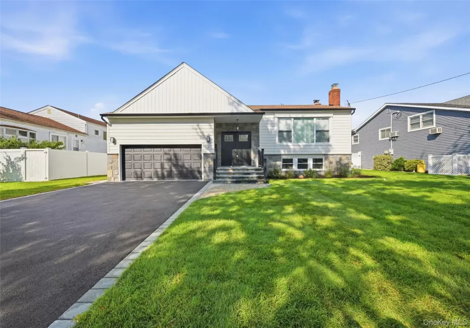 Contemporary exterior with a stone facade, a two-car garage, and a paved driveway Contemporary exterior with a stone facade, a two-car garage, and a paved driveway