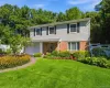 Two-story residence featuring brick and shingle siding, a two-car garage, and a stone walkway Two-story residence featuring brick and shingle siding, a two-car garage, and a stone walkway