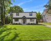 Contemporary exterior with light-colored siding, black-framed windows, a dark entry door, a covered entryway, and a landscaped front yard Contemporary exterior with light-colored siding, black-framed windows, a dark entry door, a covered entryway, and a landscaped front yard