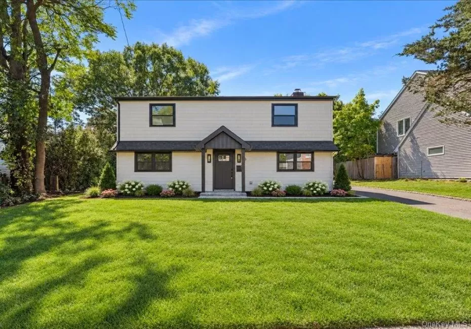 Contemporary exterior with light-colored siding, black-framed windows, a dark entry door, a covered entryway, and a landscaped front yard Contemporary exterior with light-colored siding, black-framed windows, a dark entry door, a covered entryway, and a landscaped front yard