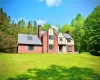 English style brick Tudor House with a chimney, board and batten siding, and a front lawn English style brick Tudor House with a chimney, board and batten siding, and a front lawn