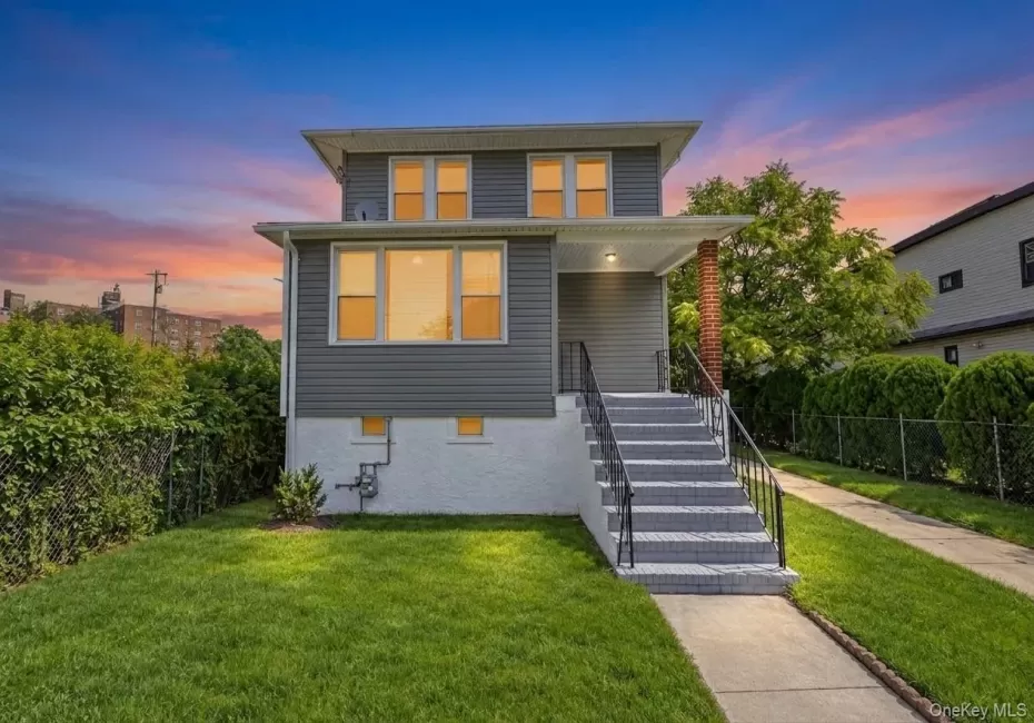 Two-story home with grey horizontal siding, white trim, and a covered front entry Two-story home with grey horizontal siding, white trim, and a covered front entry