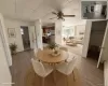 Wood-finish flooring throughout, a ceiling fan with integrated lighting, and multiple windows providing natural light Wood-finish flooring throughout, a ceiling fan with integrated lighting, and multiple windows providing natural light