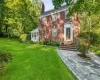 Brick exterior with a prominent chimney and a stone pathway leading to the entry Brick exterior with a prominent chimney and a stone pathway leading to the entry