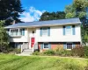 Bi-level home featuring a bay window, vinyl siding, brick accent facade, and a prominent red entry door Bi-level home featuring a bay window, vinyl siding, brick accent facade, and a prominent red entry door