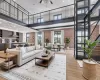 Living room featuring a high ceiling, brick wall, a ceiling fan, light wood-type flooring, and recessed lighting Living room featuring a high ceiling, brick wall, a ceiling fan, light wood-type flooring, and recessed lighting