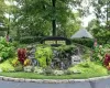Decorative community entry sign with a cascading water feature, stone surround, and diverse planted foliage Decorative community entry sign with a cascading water feature, stone surround, and diverse planted foliage