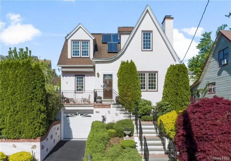 White stucco exterior with a prominent front gable, asphalt shingle roof, and solar panels White stucco exterior with a prominent front gable, asphalt shingle roof, and solar panels