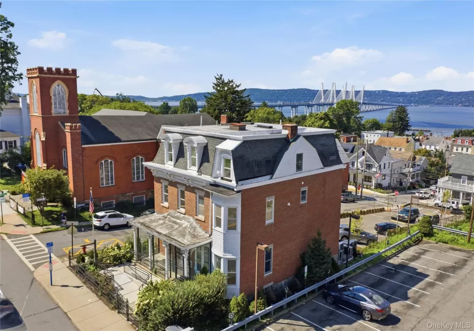 Aerial View — Historic Tarrytown ; the Hudson River. A spectacular aerial view showcasing the property in the heart of historic Tarrytown, surrounded by classic village architecture and overlooking the magnificent Hudson River. The iconic Governor Mario M. Cuomo Bridge creates a dramatic backdrop, highlighting the property’s exceptional setting between village charm and Hudson River beauty Aerial View — Historic Tarrytown ; the Hudson River. A spectacular aerial view showcasing the property in the heart of historic Tarrytown, surrounded by classic village architecture and overlooking the magnificent Hudson River. The iconic Governor Mario M. Cuomo Bridge creates a dramatic backdrop, highlighting the property’s exceptional setting between village charm and Hudson River beauty