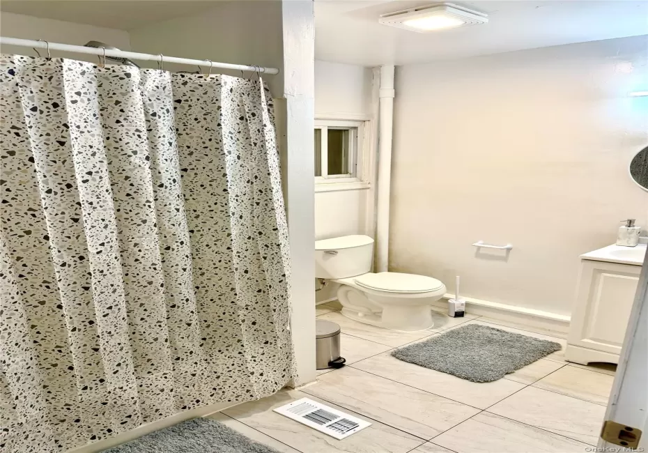 Full bath with vanity, light tile patterned flooring, and a shower with curtain Full bath with vanity, light tile patterned flooring, and a shower with curtain